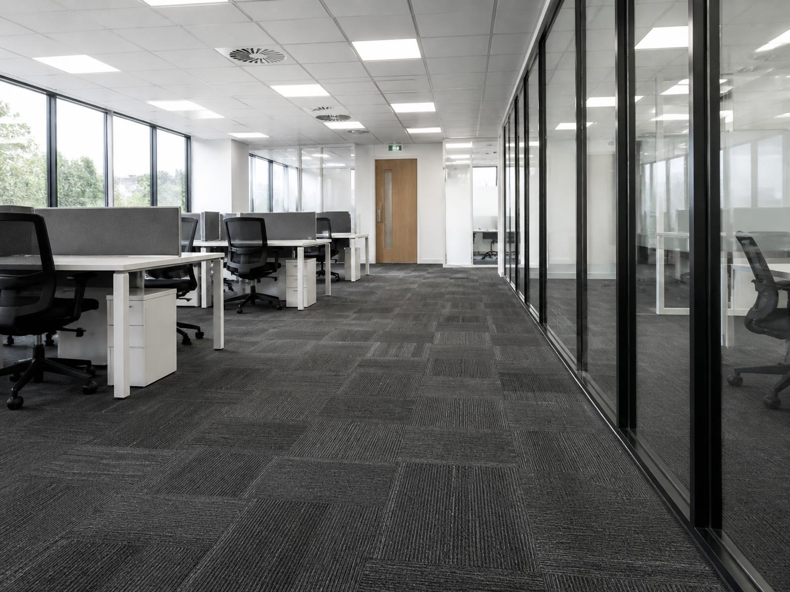 Newly installed charcoal carpet tiles in a finished open plan office